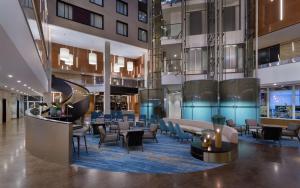 a lobby with tables and chairs in a building at DoubleTree By Hilton Moscow - Vnukovo Airport Hotel in Vnukovo