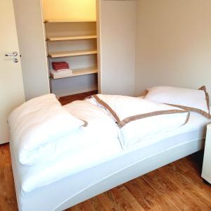 łóżko z białymi poduszkami w pokoju w obiekcie Modern central apartment next to beautiful nature2424 w Oslo