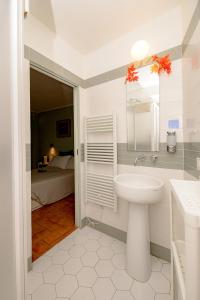 a bathroom with a sink and a mirror and a bed at La Casa del Vino in Parma