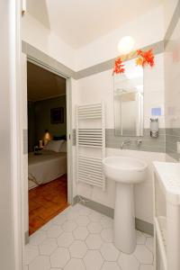 a bathroom with a sink and a mirror and a bed at La Casa del Vino in Parma +50 photos