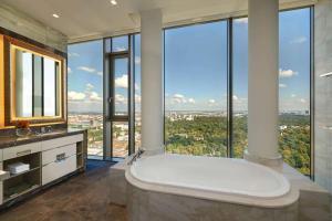 a bathroom with a large tub with large windows at Waldorf Astoria Berlin in Berlin