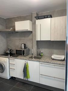 a kitchen with white cabinets and a sink at Centraal and on the ground in Rotterdam
