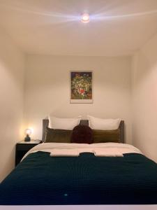 een slaapkamer met een bed met een groene deken bij Rode Bosuil: thuiskomen op De Veluwe! in Otterlo
