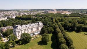 - une vue aérienne sur un grand bâtiment blanc dans l'établissement Waldorf Astoria Versailles - Trianon Palace, à Versailles