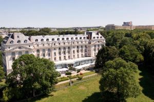 una vista aerea di un grande edificio bianco di Waldorf Astoria Versailles - Trianon Palace a Versailles