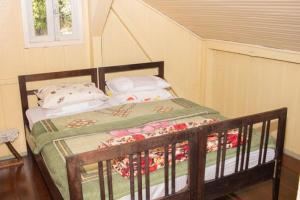 a bedroom with a bed with a wooden frame at Gasthaus Heimat in Rio Forcação