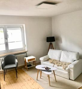 a living room with a white couch and a table at Rebenlaub in Heringen