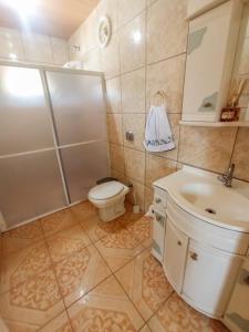 uma casa de banho com um chuveiro, um WC e um lavatório. em Gasthaus Heimat em Rio Forcação