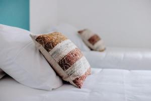 two pillows are sitting on a white bed at Logis Hôtel Restaurant Espelletenia in Larceveau-Arros-Cibits