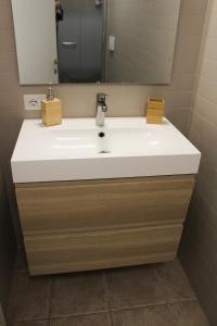 bagno con lavandino bianco e specchio di La Suite dell'Artista LUXURY ART SUITE a Stresa