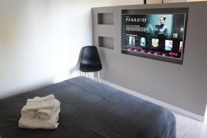 a bedroom with a bed with a tv on the wall at La Suite dell'Artista LUXURY ART SUITE in Stresa