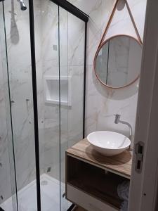 ein Bad mit einem Waschbecken und einem Spiegel in der Unterkunft Casa Container, Vista para o Lago e integrada com a Natureza - Miguel Pereira in Miguel Pereira