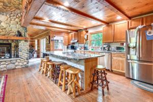 a kitchen with wooden cabinets and a large island with bar stools at Custom-Built Clarklake Cabin Sauna and Cold Plunge! in Clarklake