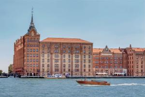 Un barco en el agua frente a un gran edificio. en Hilton Molino Stucky Venice, en Venecia
