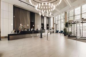 an office lobby with a reception desk and chandeliers at DoubleTree by Hilton Amsterdam Centraal Station in Amsterdam