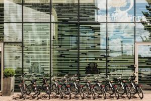 a row of bikes parked in front of a building at DoubleTree by Hilton Amsterdam Centraal Station in Amsterdam