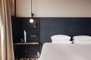 een slaapkamer met een bed met 2 kussens erop bij DoubleTree by Hilton Amsterdam Centraal Station in Amsterdam