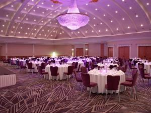 a banquet hall with tables and chairs and a purple chandelier at Hilton Antwerp Old Town in Antwerp