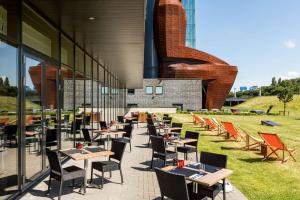 a row of tables and chairs outside of a building at Hilton Garden Inn Leiden in Leiden