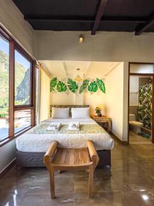 a bedroom with a large bed with a bench in it at Rupa Rupa High Jungle Eco B&B in Machu Picchu