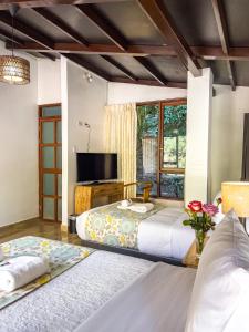 um quarto com uma cama grande e uma televisão em Rupa Rupa High Jungle Eco B&B em Machu Picchu