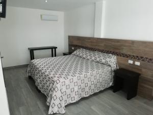 a bedroom with a large bed with a wooden headboard at HOTEL QUINTERO in Teapa