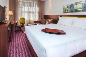 a hotel room with a large bed and a television at Hampton by Hilton Samara in Samara