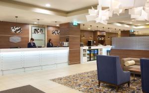 a lobby with two people standing at a counter at Hampton by Hilton Moscow Strogino in Moscow