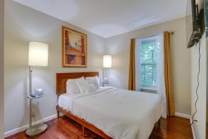 1 dormitorio con cama blanca y ventana en Roomy Columbia Retreat about 17 Mi to Dtwn Baltimore, en Columbia