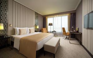 明斯克的住宿－明斯克希爾頓逸林酒店，酒店客房设有一张大床和一张书桌。