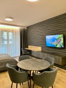 a hotel room with two tables and a flat screen tv at REMAR - Apartamenty z widokiem na Jezioro Biale in Augustów