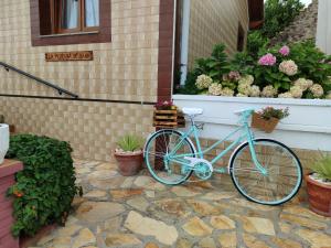 a blue bike parked outside of a house with flowers at La Morada de Sana in Suances