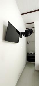 uma televisão pendurada numa parede num quarto em HOTEL BUGANVILIA em Oiba