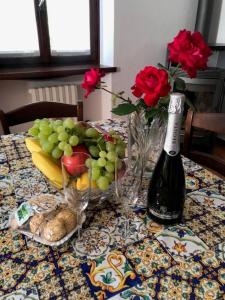 a table with a bunch of fruit and a bottle of wine at Villetta Indipendente in San Zeno di Montagna