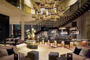 una hall con bar e un grande lampadario a braccio di Hilton Tallinn Park a Tallinn