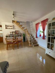 a living room with a dining table and a staircase at Pensiunea Agroturistica Casa Tarta 