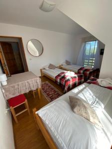 a room with two beds and a table and a mirror at Pensiunea Agroturistica Casa Tarta 