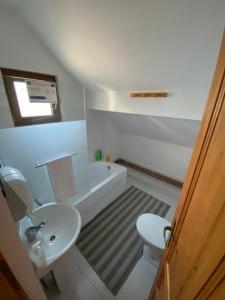 a bathroom with a sink and a toilet and a tub at Pensiunea Agroturistica Casa Tarta 