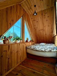 a bedroom with a bed in a wooden room with a window at Domek Stojkowo in Stojkowo