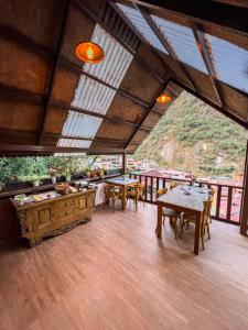 Habitación con mesas, sillas y ventana grande. en Rupa Rupa High Jungle Eco B&B, en Machu Picchu
