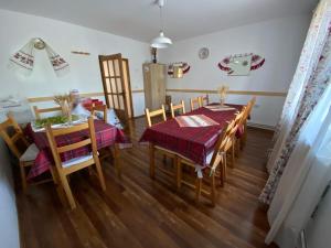 a kitchen and dining room with a table and chairs at Pensiunea Agroturistica Casa Tarta in Livada