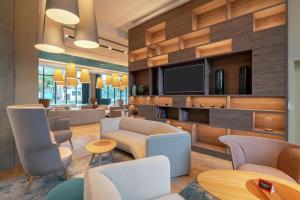 a lobby with a waiting room with chairs and a tv at Hampton By Hilton Warsaw Mokotow in Warsaw