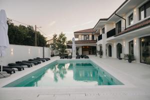 a swimming pool in front of a house at Luuma in 2 Mai