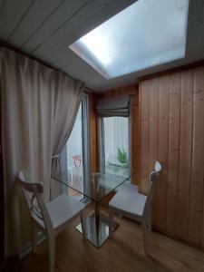 a dining room with a glass table and two chairs at Garden Studio Cottage in London