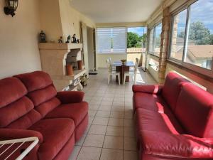 a living room with a red couch and a fireplace at La Lauzière in Cardet +16 photos