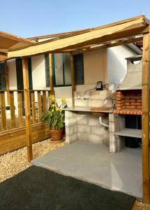 a patio with a grill on a deck at Coqueta casita Playa Palmar-300m-Zoco in El Palmar