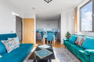 a living room with a blue couch and a table at London City View apartment short walk to Tower Bridge, Free Car Parking in London