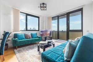 a living room with blue furniture and large windows at London City View apartment short walk to Tower Bridge, Free Car Parking in London