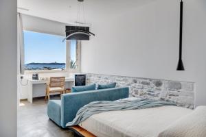 Un dormitorio con una cama azul y una pared de piedra en NOS Suites en Ermoupoli