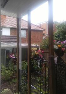 a porch with a fence with flowers on it at Garden Studio Cottage in London